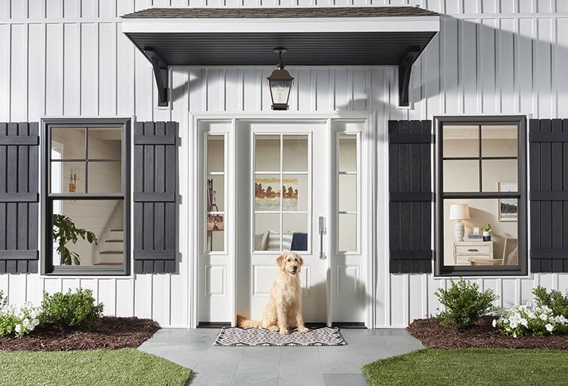 white house with wood windows and a dog